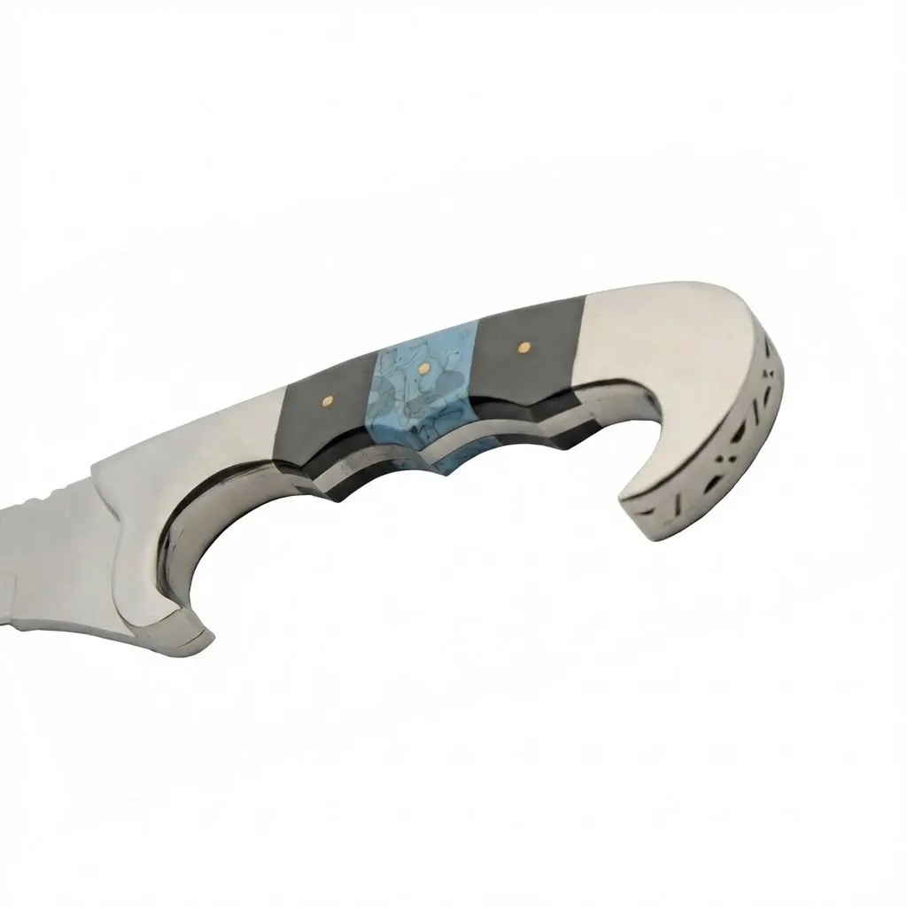 falcata-knife-handle-turquoise-inlay Close up of the knife handle featuring black scales, turquoise inlay, and decorative metal pommel.