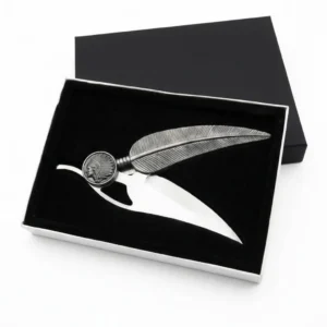 Open silver feather folding knife resting against black presentation box