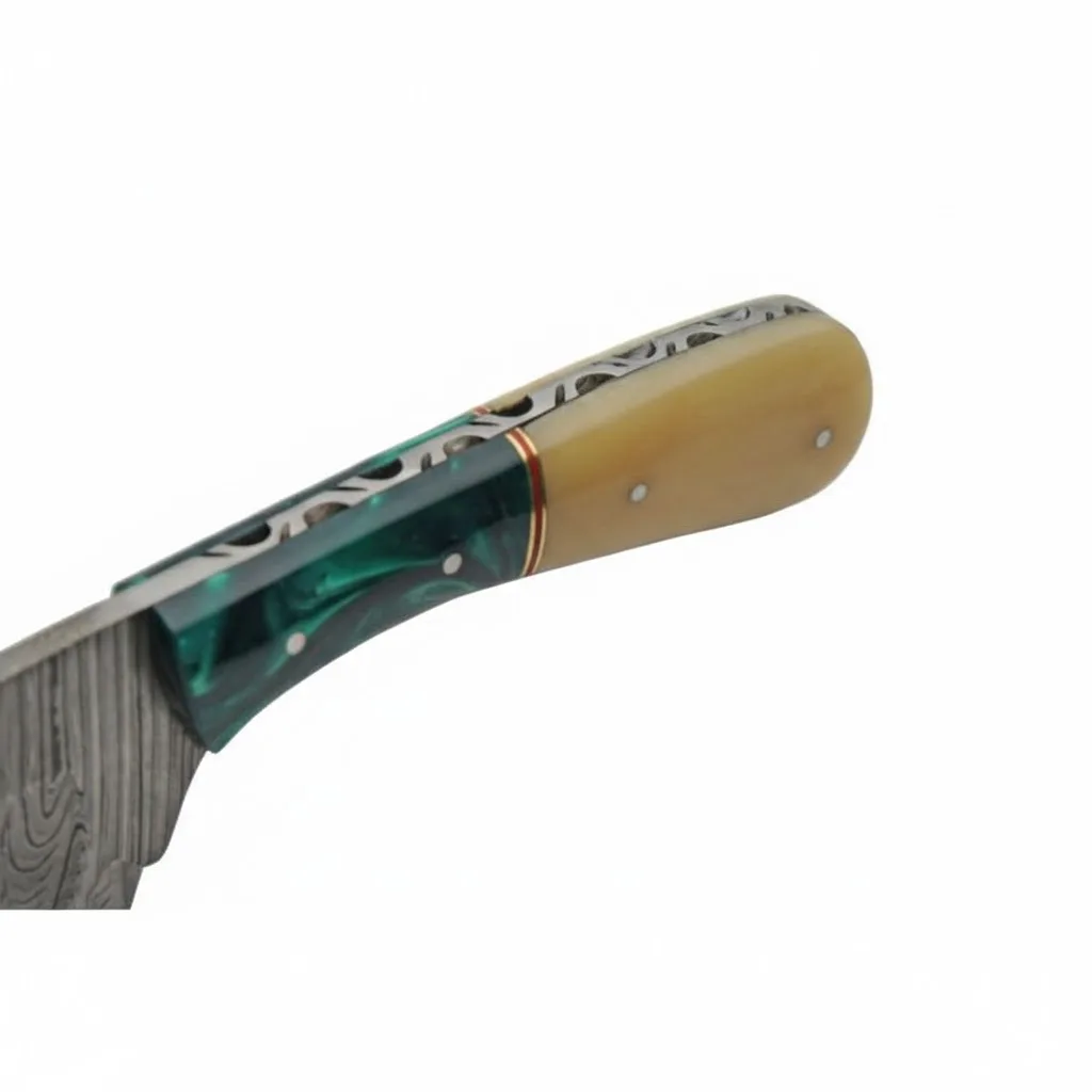 damascus-knife-decorative-spine-filework Close-up of a knife handle showing intricate decorative filework along the steel spine and dual-tone scales.