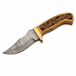 Close-up of a Damascus steel skinner blade showing the forged pattern and sharp edge.